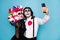 Photo of creepy couple man lady cuddle hold telephone make selfie video call friend wear black dress death costume mask
