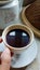 Photo of a cup of coffee and a mug with a traditional theme, using a ceramic base material