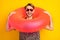 Photo of cute funny young gentleman dressed print shirt dark glasses holding head swim circle isolated yellow color