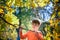 Photo of cute little boy enjoying autumnal nature, pretty infant playing in park, cheerful baby boy having fun outdoors, adorable