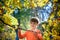 Photo of cute little boy enjoying autumnal nature, pretty infant playing in park, cheerful baby boy having fun outdoors, adorable