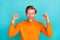 Photo of cute lucky guy dressed orange sweater eyewear screaming rising fists isolated turquoise color background