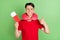 Photo of cute pretty young man wear red t-shirt neck pillow holding tickets showing thumb up isolated green color