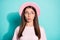 Photo of cute tricky girl lady dressed pink t-shirt hat pouted lips look empty space isolated teal color background