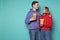 Photo of cute young couple in casual clothes with popcorn in hands
