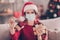 Photo of cute young ill girl hold many packs meds thermometer wear mask santa cap red pullover decorated living room