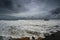 Photo of dark clouds over Sunshine Coast with foamy and rocky shore in Queensland, Australia