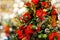 Photo of decorated Christmas spruce with red flowers, pine cones, berries in store