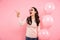 Photo of delighted adult girl with long dark hair in round glass