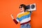 Photo of delighted funny girl fist celebrate look empty space hold boom box isolated on orange color background