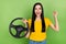 Photo of delighted girl hold wheel raise fist celebrate luck look camera isolated on green color background