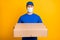 Photo of deliveryman hold package wear medical face safe respiratory isolated on yellow color background