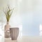 A photo of a desk with a white-gray vase with dried grass and a gray cup with coffee