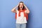 Photo of despair shocked angry young adult woman dressed white T-shirt and orange jumper tied over shoulders standing against blue