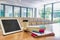 Photo of digital tablet, books and cup of coffee on table in classroom