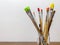 Photo of dirty paint brushes in glass jar on wooden table