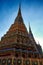 The photo displays ornate temple spires in Thailand, bedecked with colorful tiles and patterns, glowing in the warm light of the
