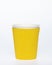 Photo of a disposable yellow  paper cup on a white background. Photo of a coffee cup made of recyclable materials