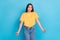 Photo of doubtful funny pretty girl dressed yellow clothes shrugging shoulders cant choose outfit isolated on blue color