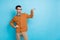 Photo of doubtful funny young guy dressed brown cardigan glasses measure arm empty space isolated blue color background