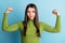 Photo of doubtful uncertain lady raise muscular hands grimace wear green turtleneck isolated on blue background