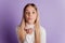 Photo of dreamy affectionate lady send air kiss wear white jumper posing on purple background