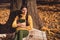 Photo of dreamy calm peaceful girl forest countryside tourist sit under fall lawn park maple leaves tree checkered