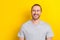 Photo of dreamy cheerful guy dressed grey t-shirt looking empty space isolated yellow color background