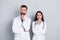 Photo of dreamy clever two docs dressed white coats looking empty space hands arms chins isolated grey color background