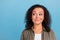 Photo of dreamy minded young afro american woman look empty space idea imagine isolated on blue color background