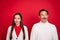 Photo of dreamy positive mature man and woman couple christmas look empty space isolated on red color background