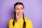 Photo of dreamy tricky young lady pigtails dressed yellow sweater looking empty space biting finger isolated violet