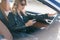 Photo of driver girl with phone in hands sitting in car