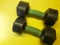 Photo of dumbbell hand muscle exercise equipment with a yellow background