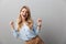 Photo of ecstatic blond businesswoman with long curly hair laughing and clenching her fists