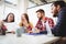 Photo editor showing documents to coworkers in meeting room