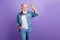 Photo of elderly man happy positive smile show fingers hello salute look empty space isolated over purple color