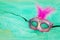 Photo of elegant and delicate pink and purple Venetian mask over mint chiffon background