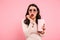 Photo of emotional or confused brunette woman drinking cold soda