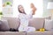 Photo of excited amazed emotional positive lovely lady play toy bear open mouth sit sofa wear kigurumi indoors