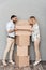 Photo of excited caucasian couple in casual clothing opening cardboard box