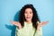 Photo of excited crazy brunette lady open mouth hold palms look camera wear green sweater isolated blue background
