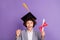 Photo of excited crazy winner schoolboy hold diploma enjoy triumph wear hat grey suit isolated violet color background