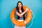 Photo of excited lady long hair hold orange emergency life buoy directing finger empty space advising cheap cruise liner