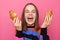 Photo of excited laughing woman with brown hair wearing sweater, holding two croissants in hands, screaming, feels hungry, posing