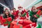 Photo of excited lucky santa claus assistants wear costumes smiling rising fist buying many gift packages indoors