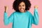 Photo of excited screaming african american young woman standing over pink background.