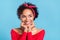 Photo of excited thoughtful afro girl wear off-shoulders red shirt arms cheeks looking empty space smiling isolated blue