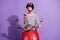 Photo of excited young lady ride moped hold telephone crazy face wear helmet striped shirt isolated purple color