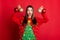 Photo of exciting shiny young woman dressed ugly pullover smiling holding christmas decorations isolated red color